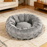 Woven donut dog bed in green on a living room rug