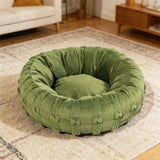 Yorkshire terrier resting in grey woven donut dog bed