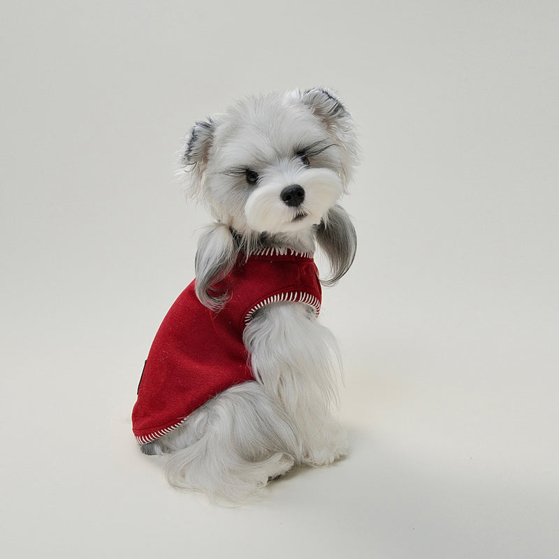 Small dog wearing red fleece vest showing back detail and cute embroidered leather patch