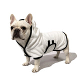 Schnauzer wearing white pet bathrobe towel in bathroom
