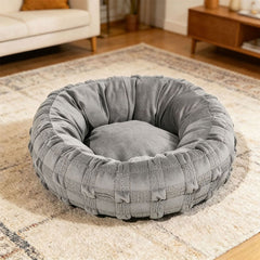 Woven donut dog bed in green on a living room rug