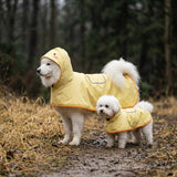 Two dogs wearing yellow duck poncho raincoats - back view